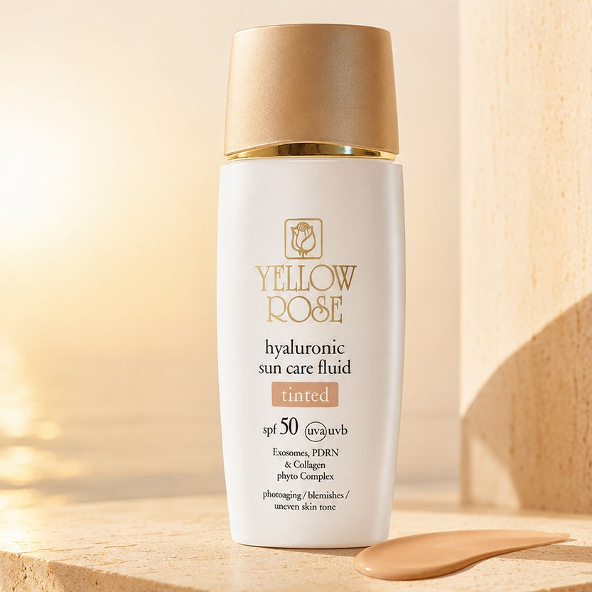 Yellow Rose Hyaluronic Suncare Fluid SPF50 Tinted Light med färgprov på varmbeige bakgrund